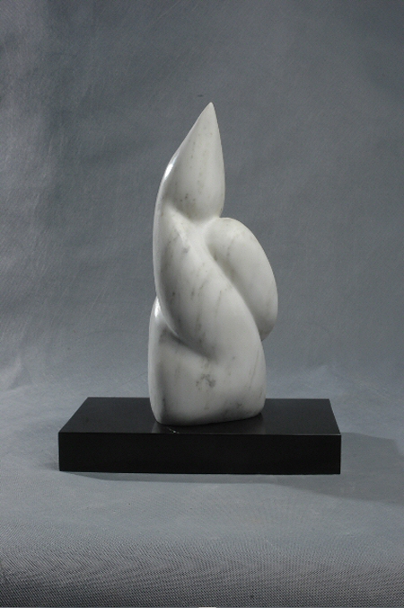 small abstract sculpture in white marble, reminiscent of an earth form